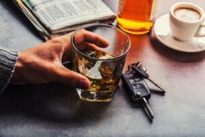 guy holding alcohol and car keys