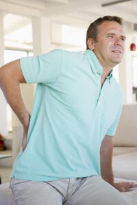 Las Vegas Slip and Fall Lawyer: Man in a light blue polo shirt holding his lower back in pain