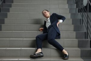 woman in business suit slipping and falling on stairs