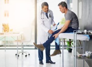 A patient holding his leg, asking his doctor how he can apply for disability in Nevada