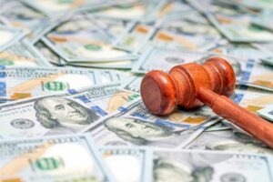 Gavel sitting on a pile of money to symbolize H&P Law’s $477k victory for an incorrect plasma withdrawal victim.