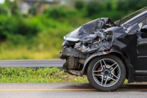 A crushed front end of a car that was hit by a UPS truck.