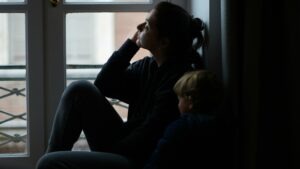 An upset mother looking out the window. What are the legal options for families after child sexual abuse?