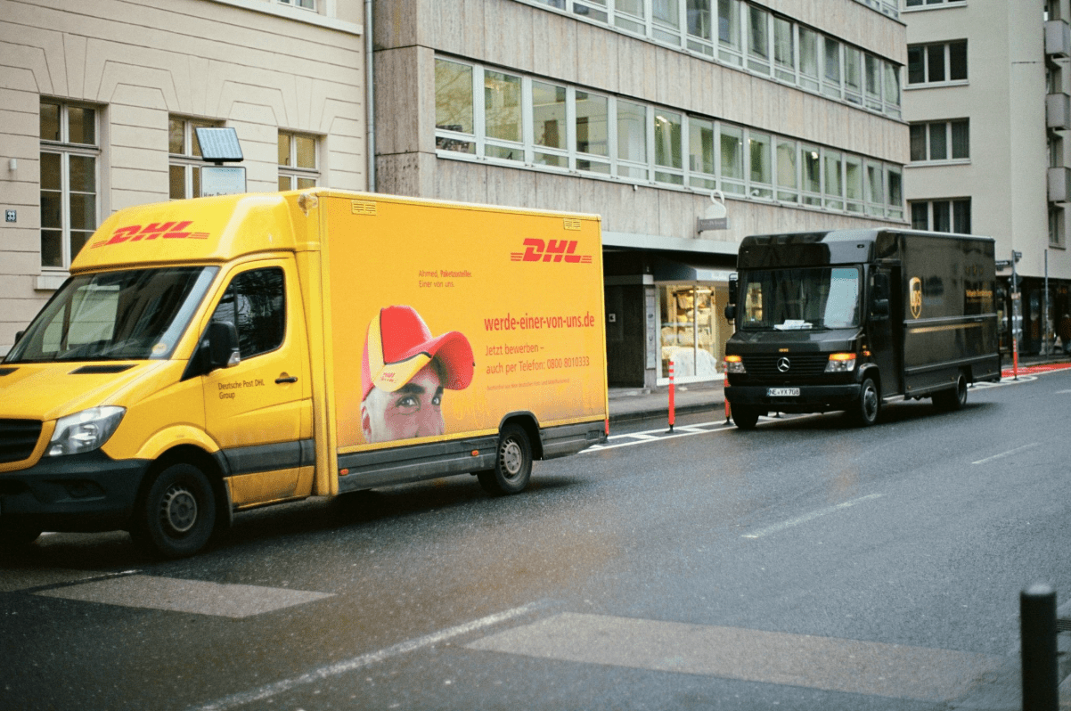 A DHL and UPS delivery truck in an urban area.